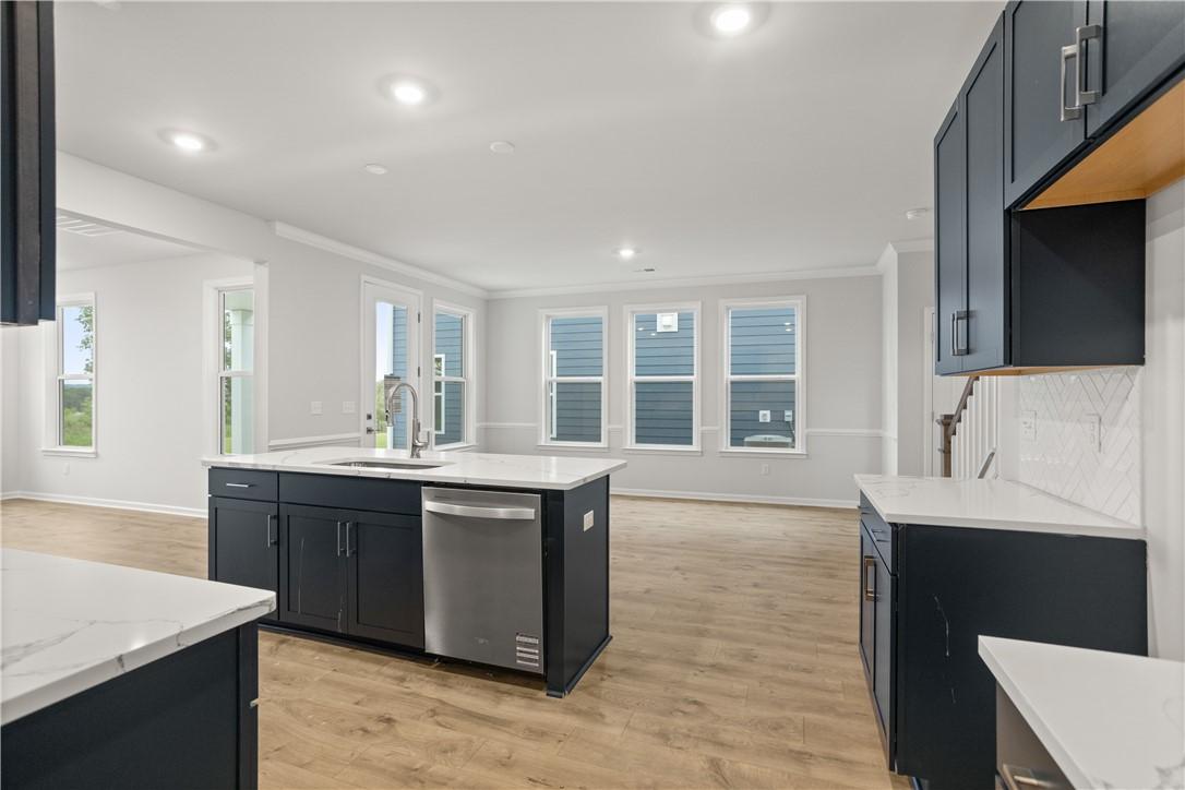 Image 4: A well-lit kitchen with a central island and conte