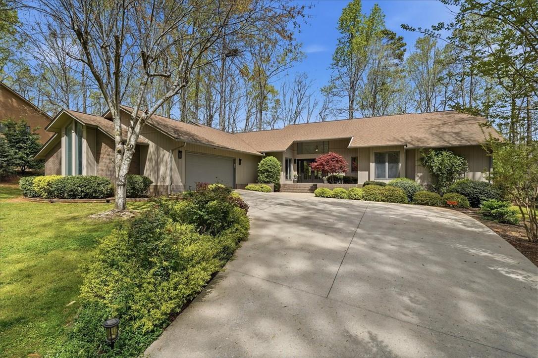 Image 3: This contemporary home boasts a generous driveway,