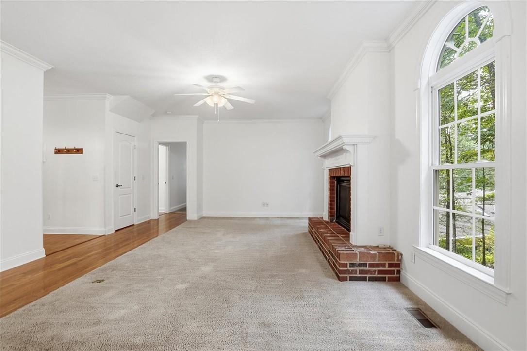 Image 4: A classic brick fireplace anchors this inviting li