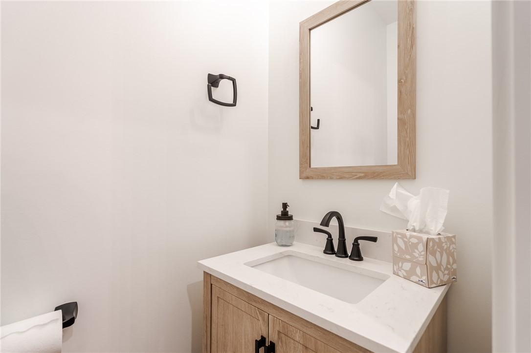 Image 4: A well-appointed powder room features a natural wo