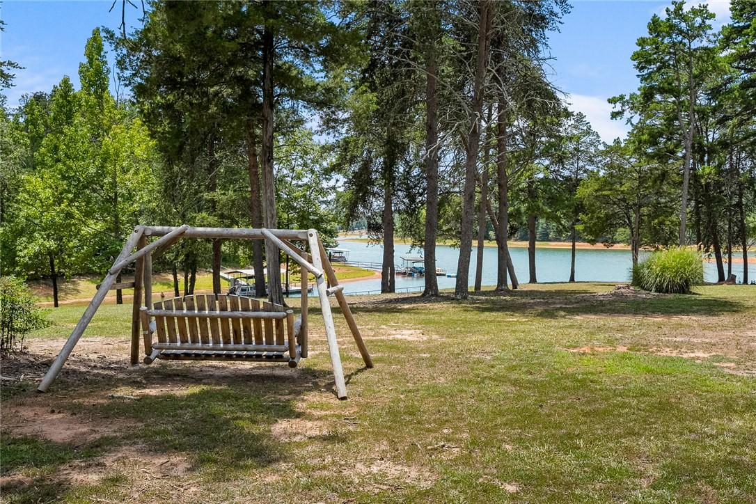 Image 3: A rustic wooden swing offers tranquil lakeside vie