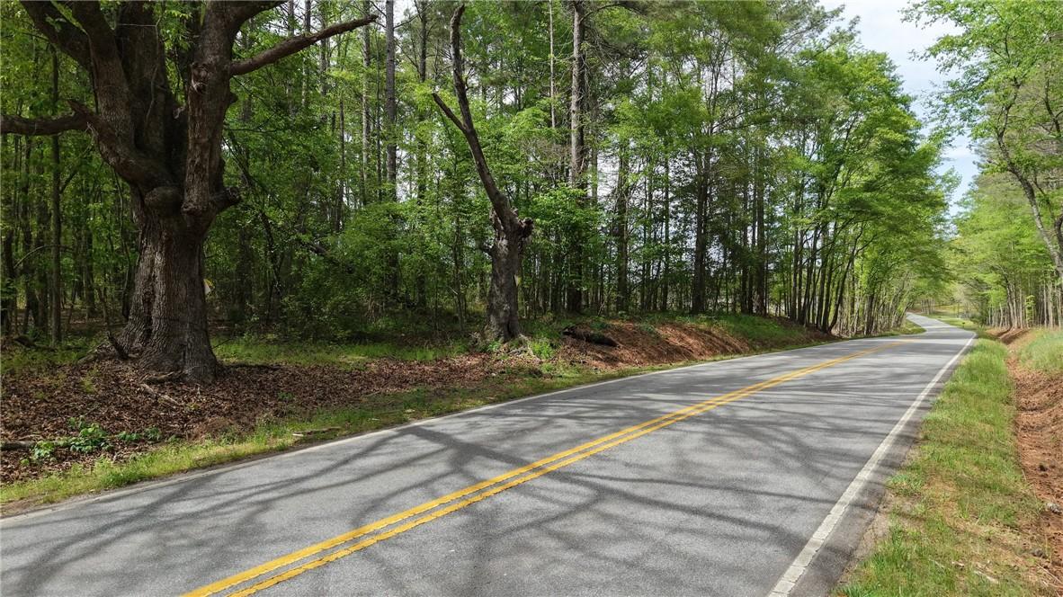 Image 2: A picturesque road winds through lush, verdant tre