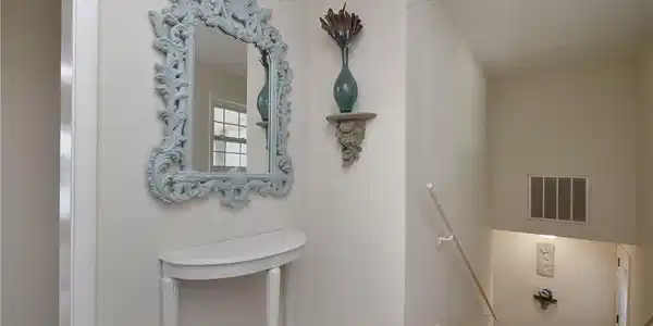 Image 3: A graceful console table and ornate mirror adorn t