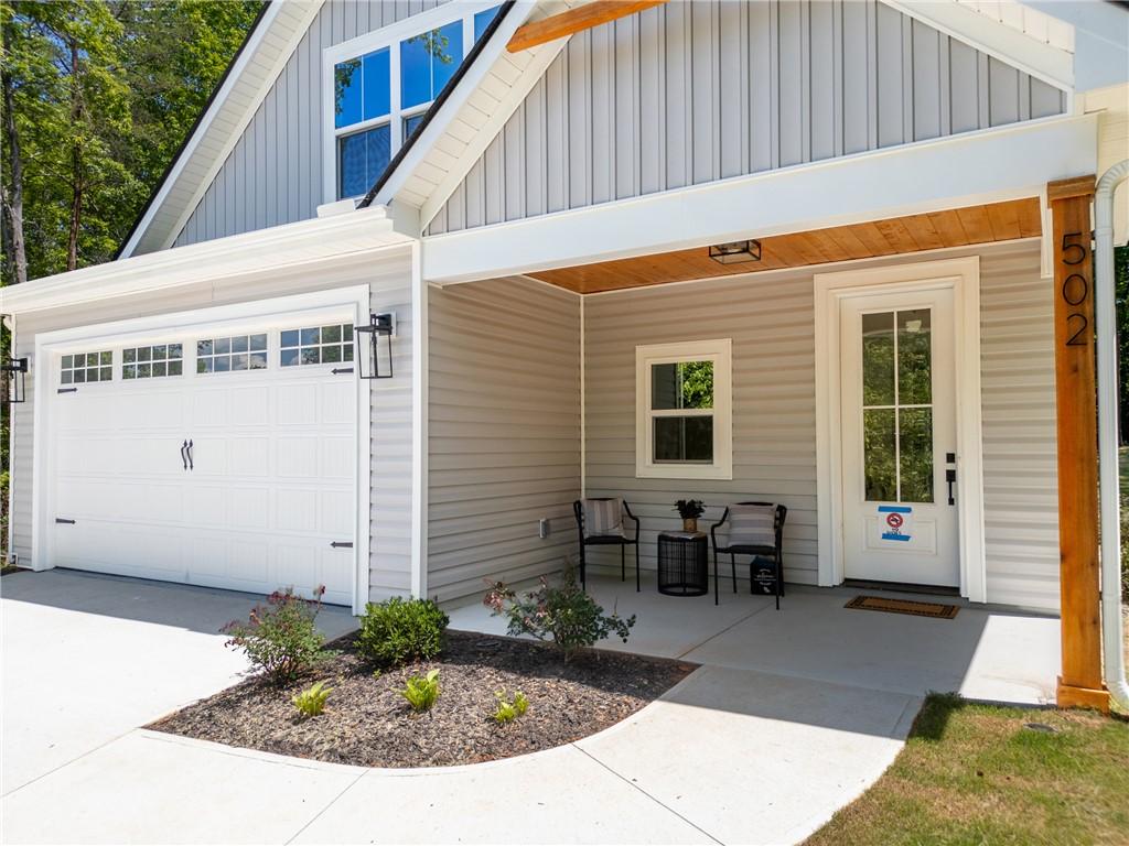 Image 2: A welcoming covered porch and attached garage enha