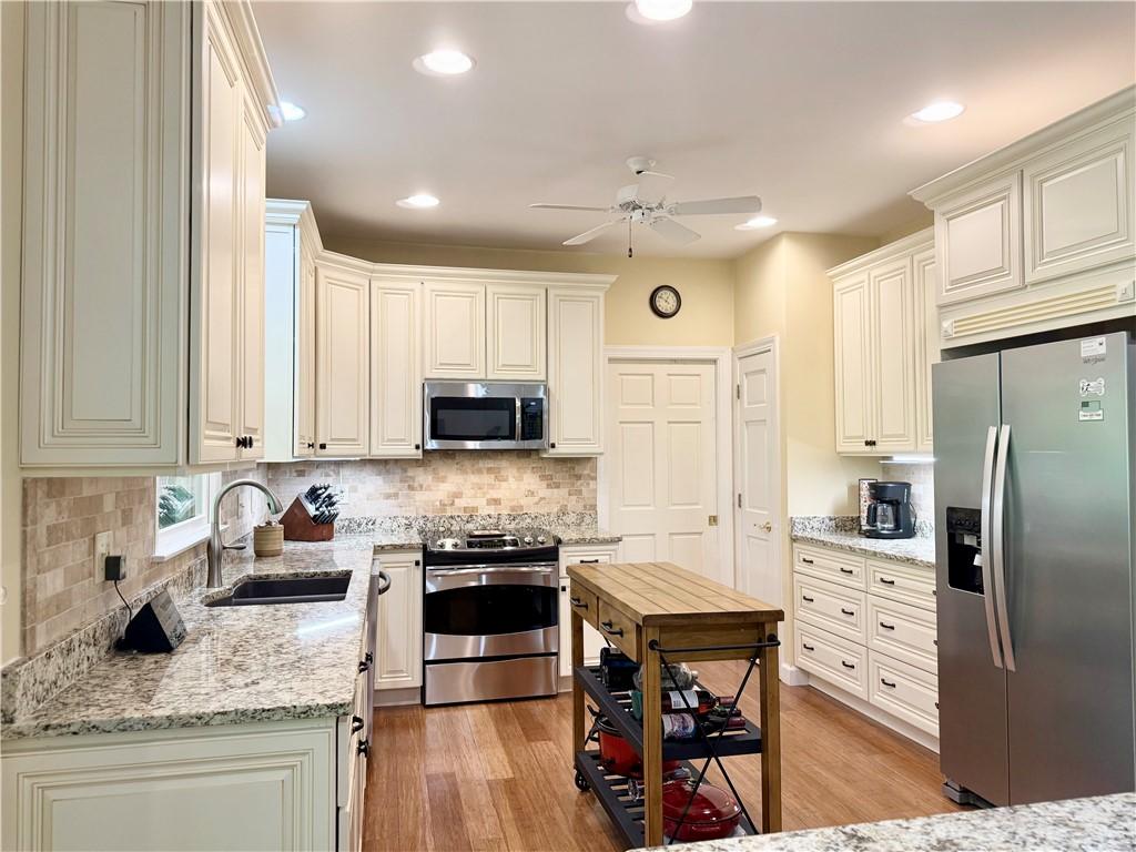 Image 3: This spacious kitchen features ample cabinetry and