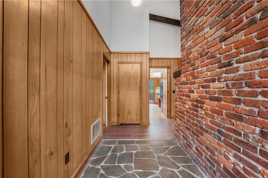 Image 4: This entry features a brick wall, wood paneling, a