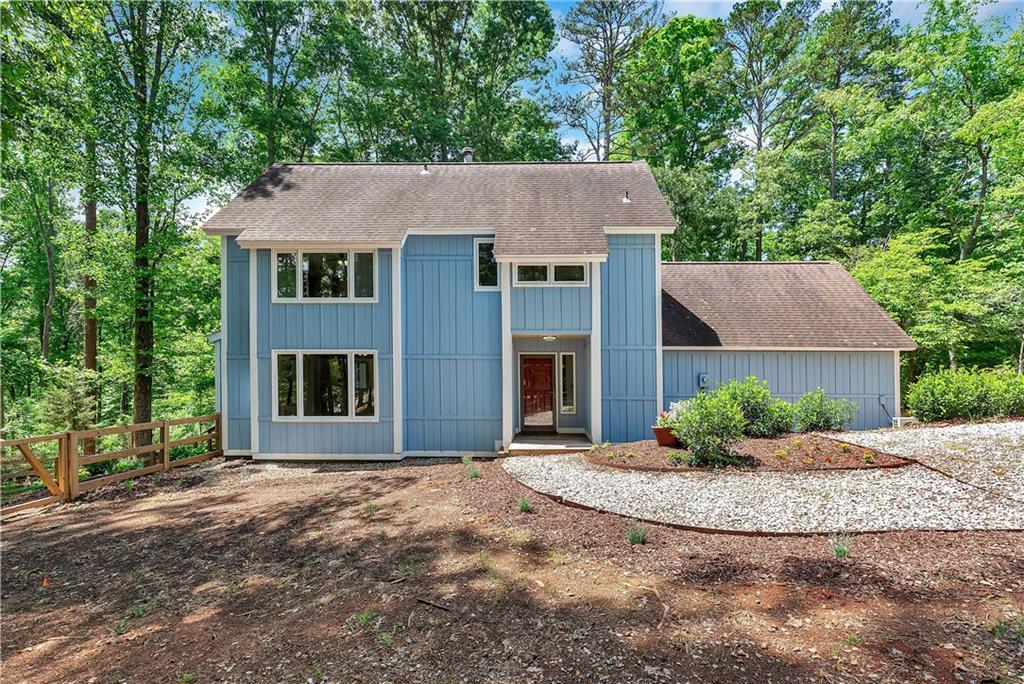 Image 1: A striking blue facade nestled amongst mature tree