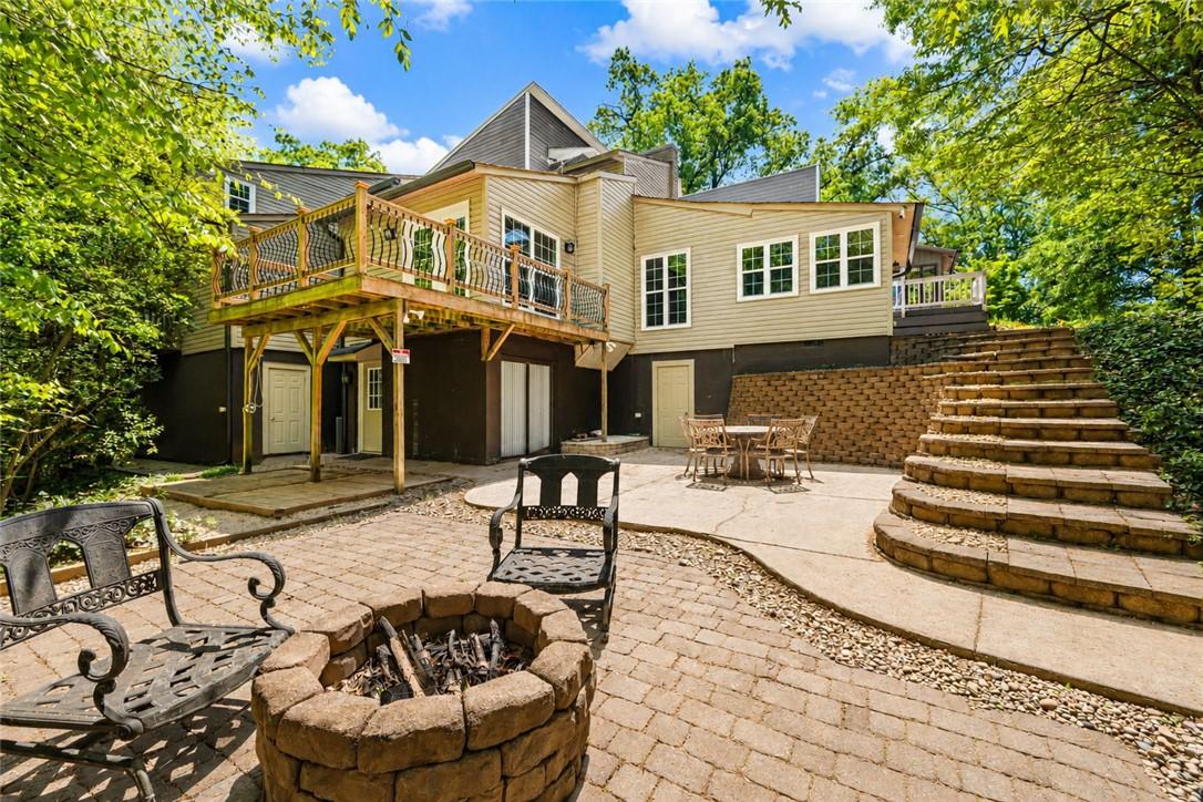 Image 1: An inviting backyard oasis offers a fire pit, dini