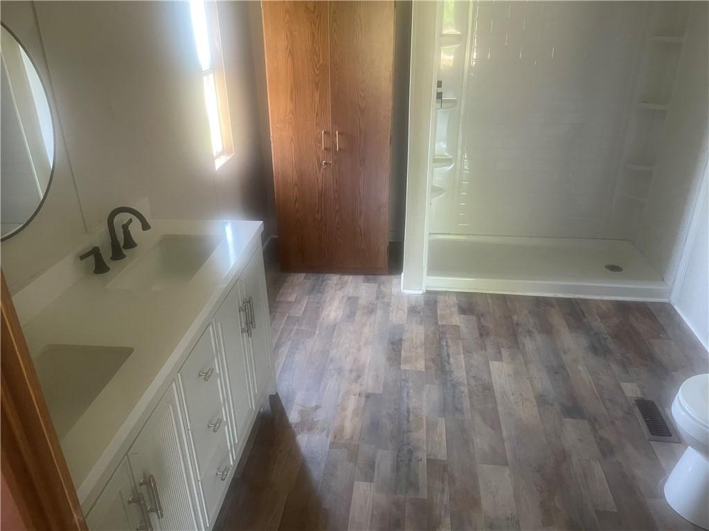 Image 2: This bright bathroom features a spacious shower an