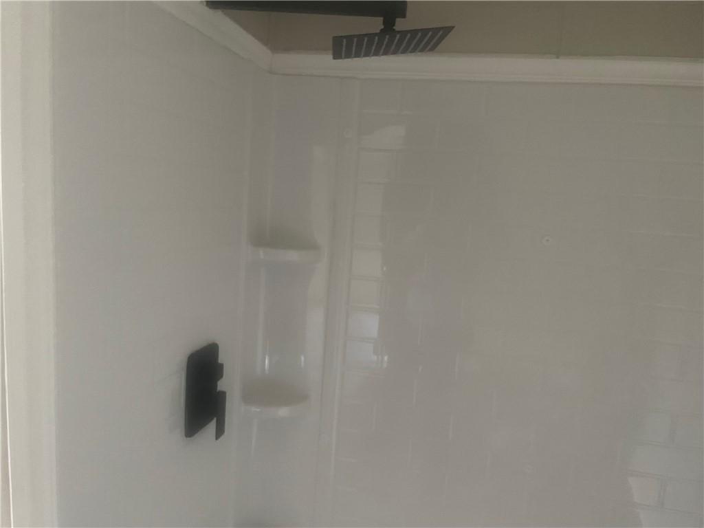 Image 4: This modern shower features sleek fixtures and pra
