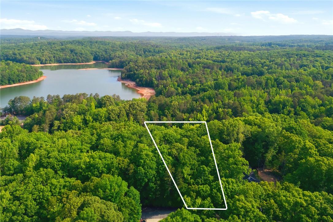 Image 1: A verdant parcel bordering serene lake waters offe