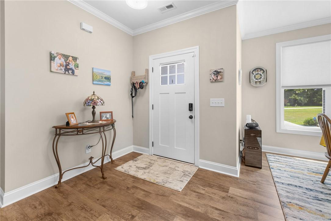 Image 4: A welcoming entry features durable wood flooring a