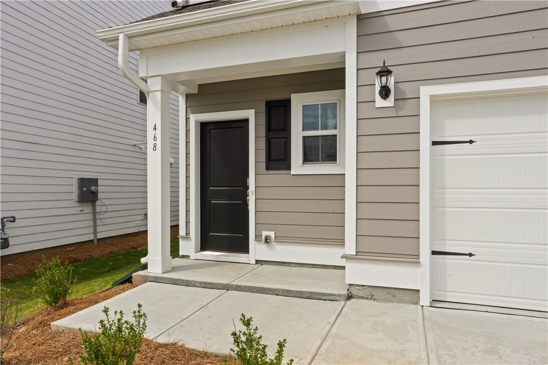 Image 3: A welcoming front entry with a black door and gara