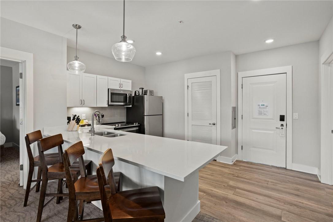 Image 3: This modern kitchen features sleek countertops, st