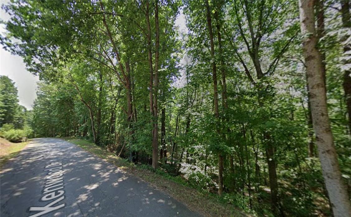 Image 1: Vast, verdant woodlands line the quiet residential