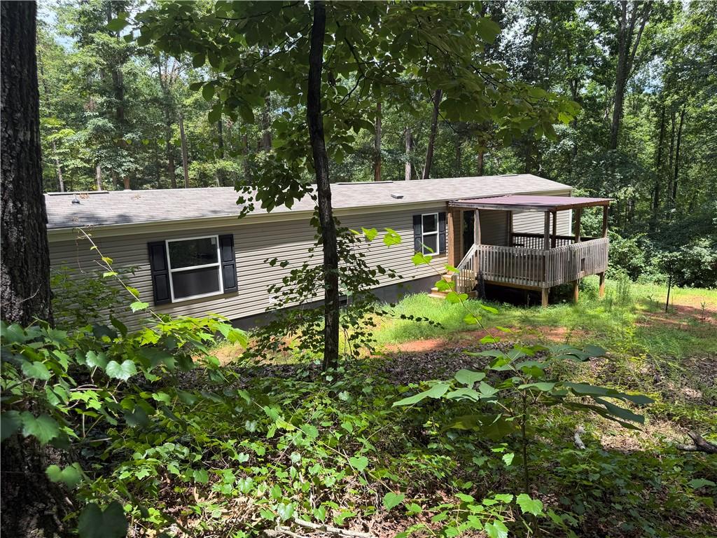 Image 1: A private wooded setting surrounds this cozy home