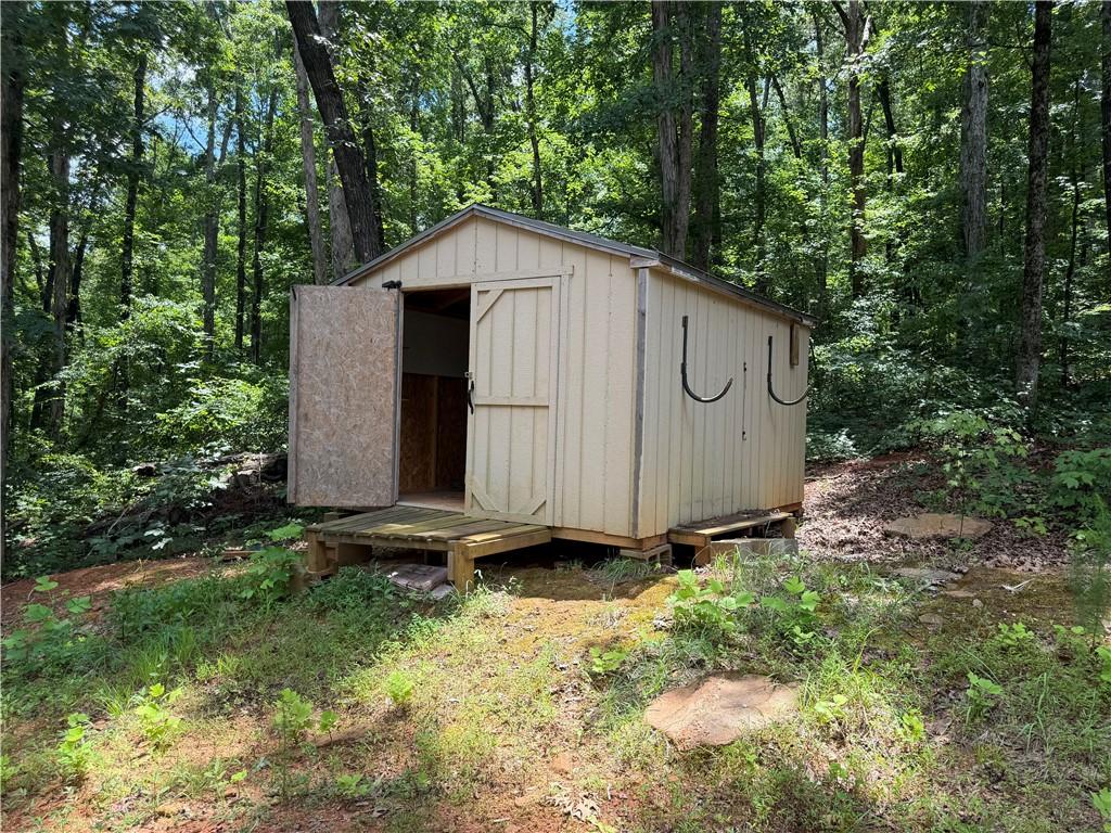 Image 2: A quaint outbuilding offers practical storage amid