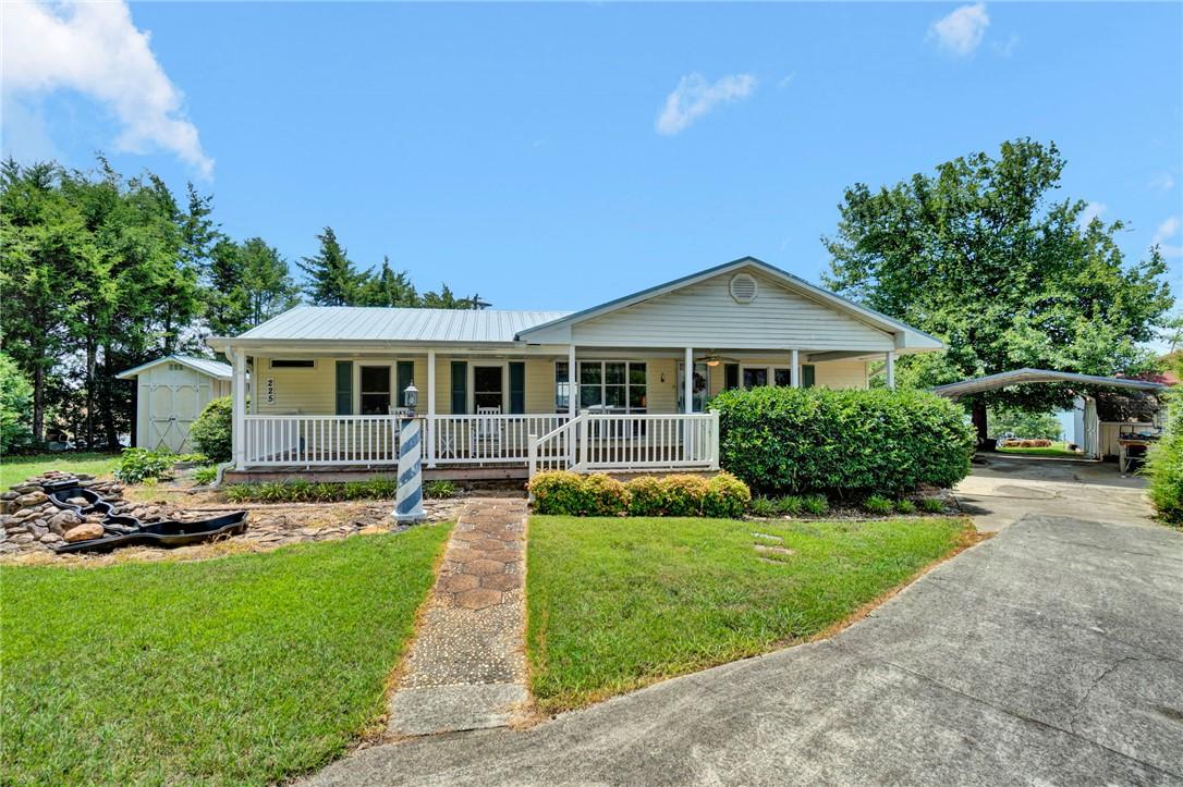 Image 2: A welcoming front porch extends across this charmi