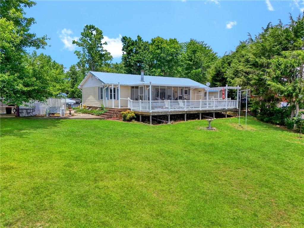 Image 4: A broad, green lawn surrounds this home, featuring
