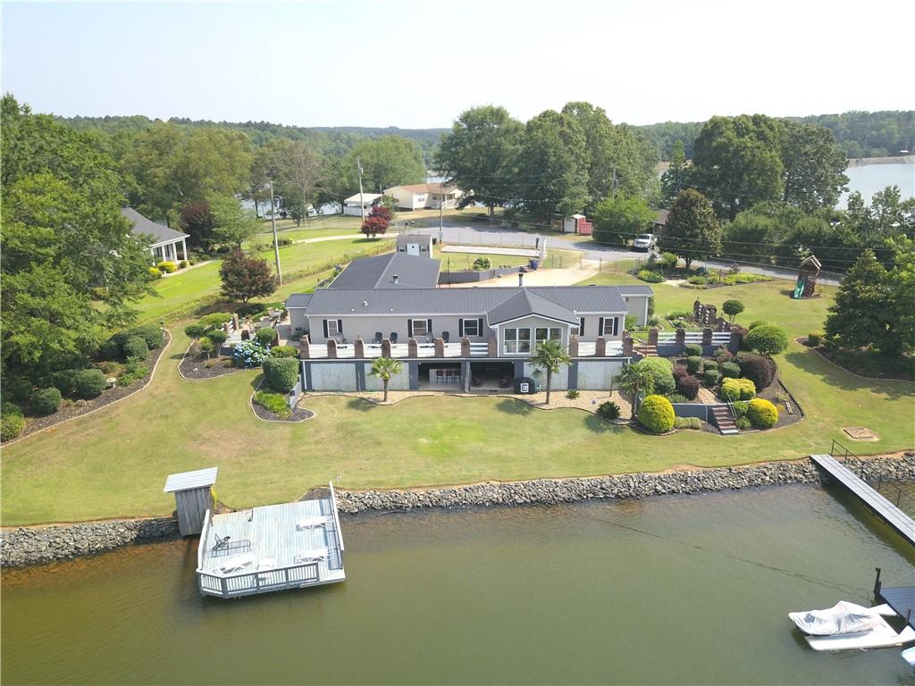 Image 1: This captivating lakefront home features a private