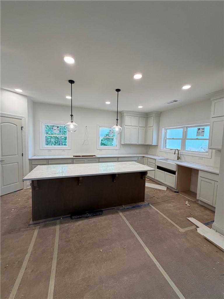 Image 3: An airy kitchen space features recessed lighting,
