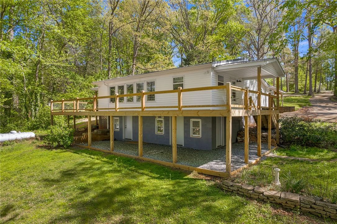 Image 2: This charming home offers an elevated deck, perfec