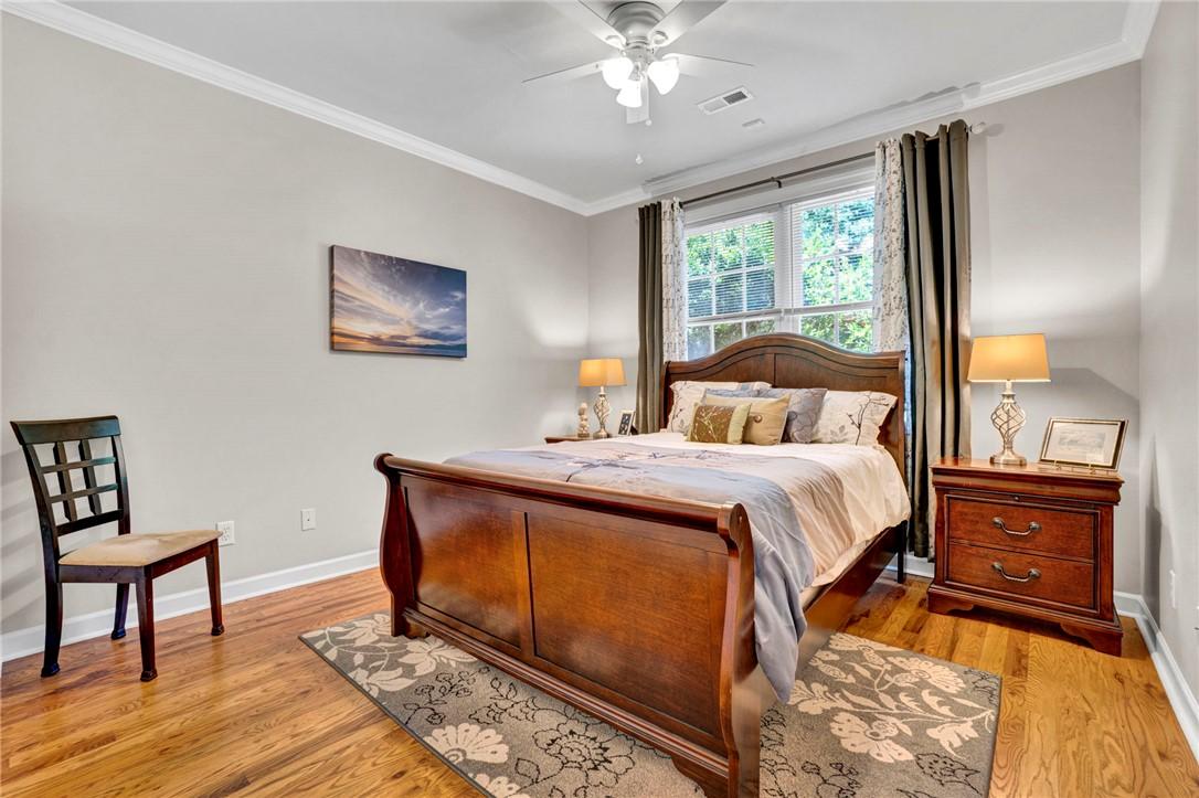 Image 3: This spacious bedroom offers gleaming hardwood flo