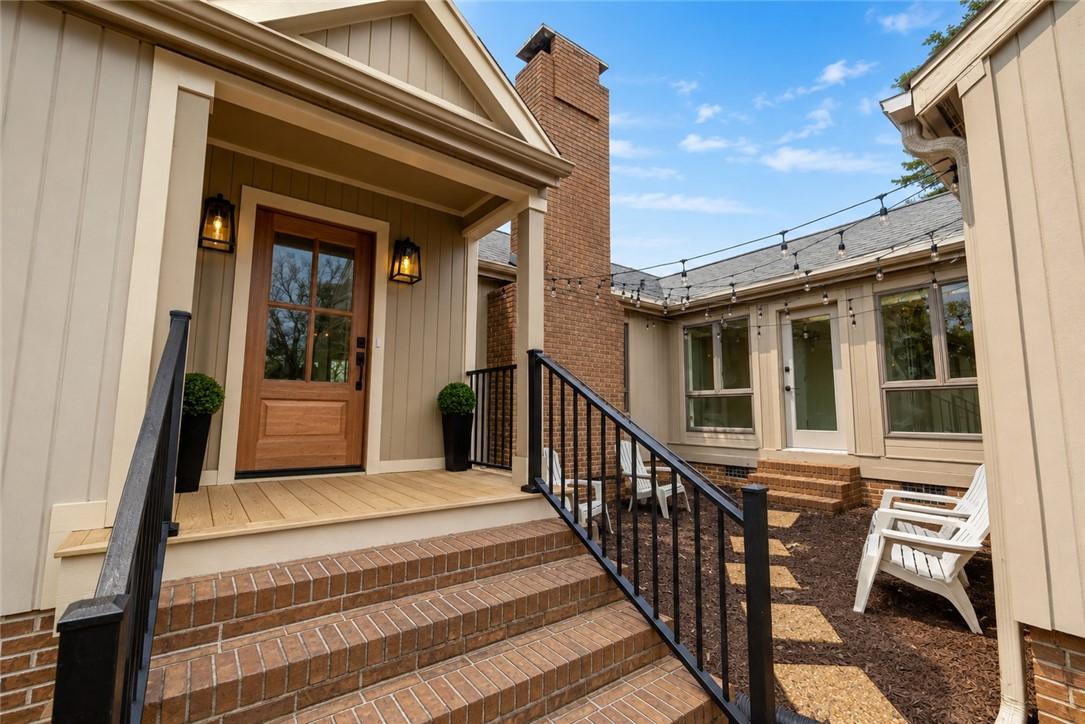 Image 4: A welcoming front porch features warm wood and bri