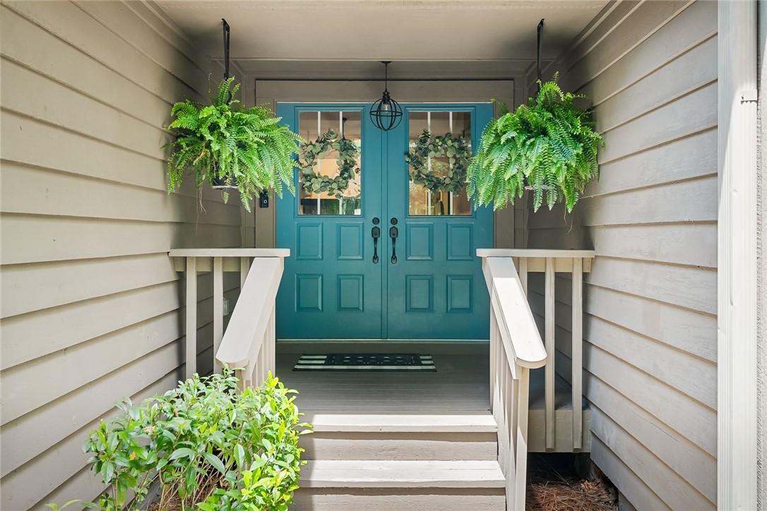 Image 2: A welcoming entry features double teal doors and h