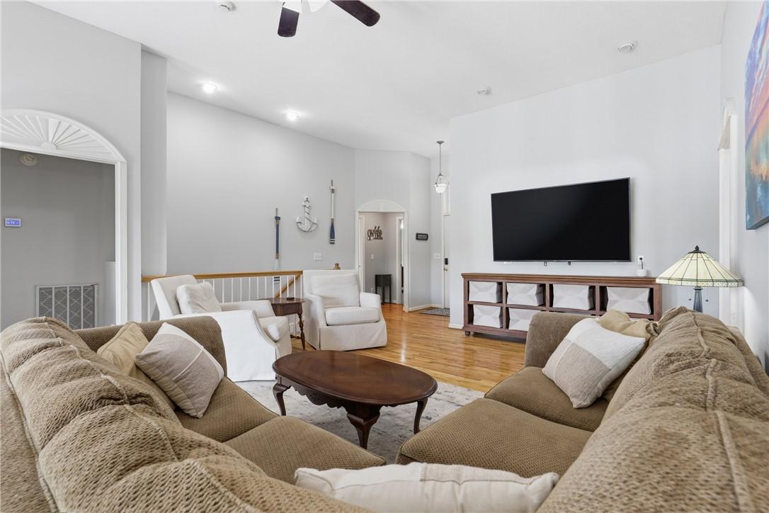 Image 4: This living room features vaulted ceilings and har