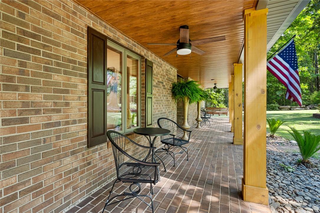 Image 2: An inviting brick facade with a wide, shaded porch