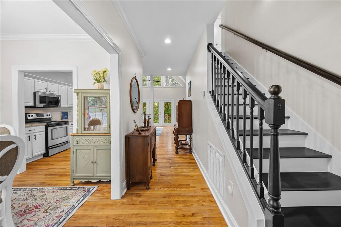Image 3: Hardwood floors lead to a kitchen with stainless s