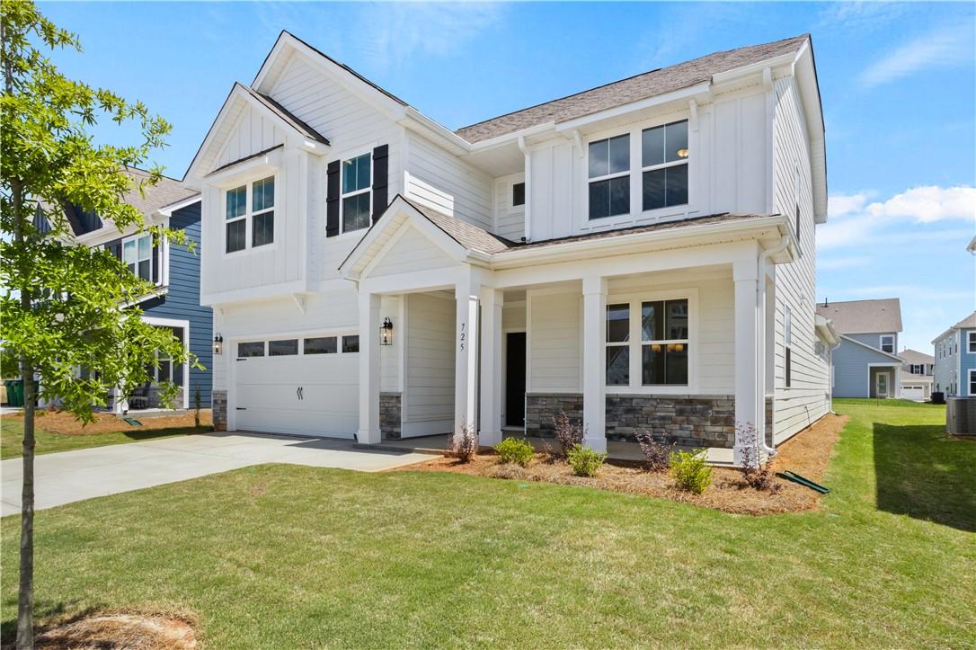 Image 2: White siding with stone accents and a welcoming co