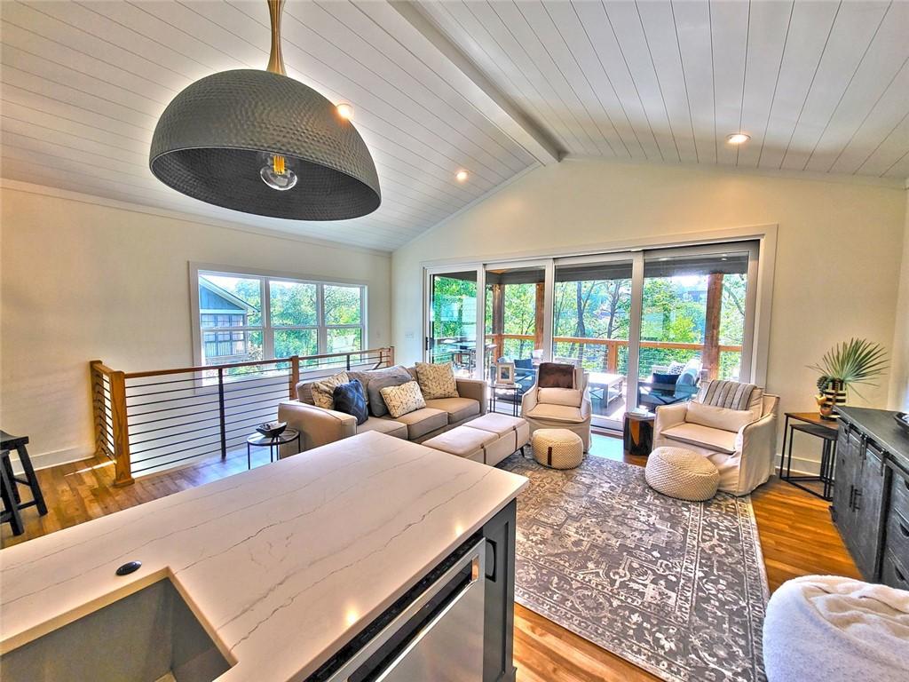 Image 4: Bright and open living area with rich wood floors