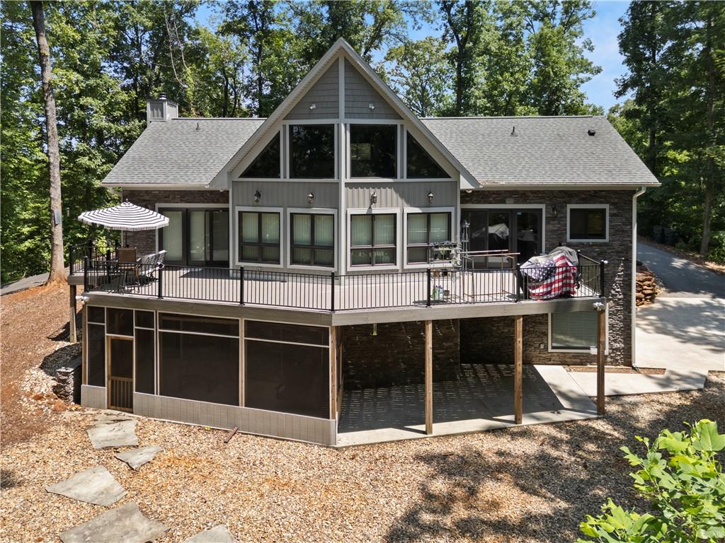 Image 1: A striking home with a spacious deck and screened-
