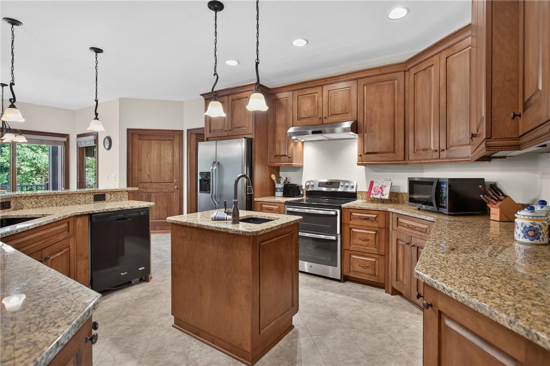 Image 2: A well-appointed kitchen features rich wood cabine