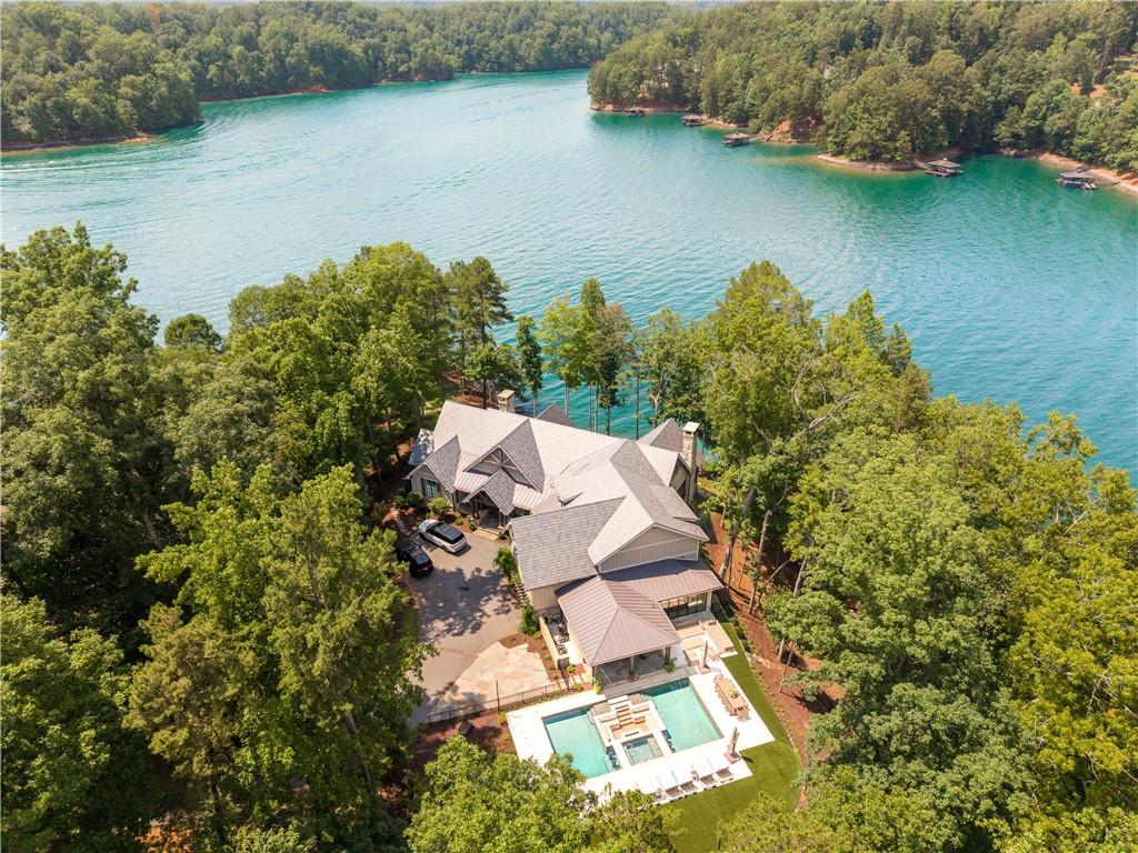 Image 2: Nestled among verdant trees, this grand lakeside r