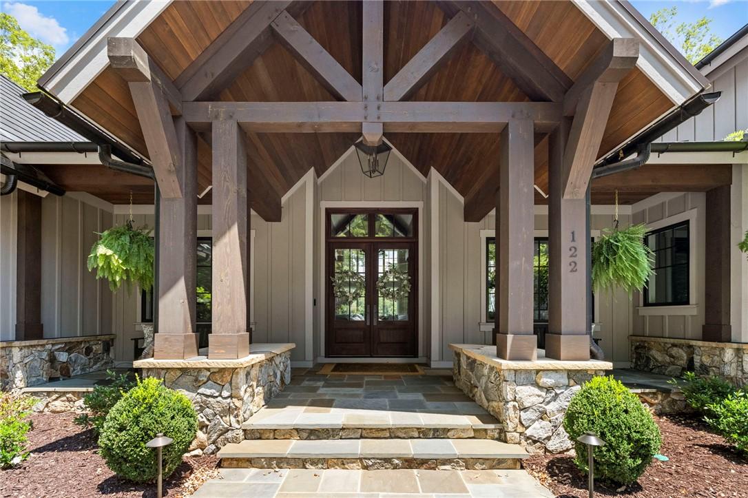 Image 3: A striking timber-framed entryway with stone accen