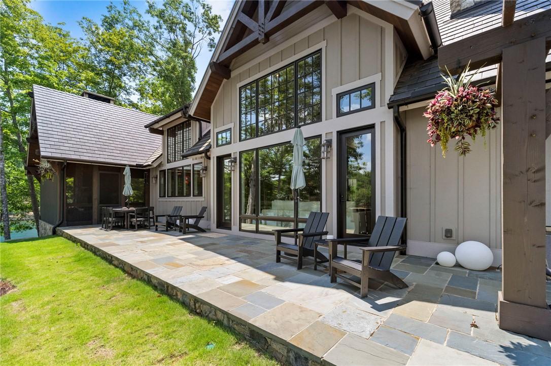 Image 4: A spacious stone patio extends from this lakeside