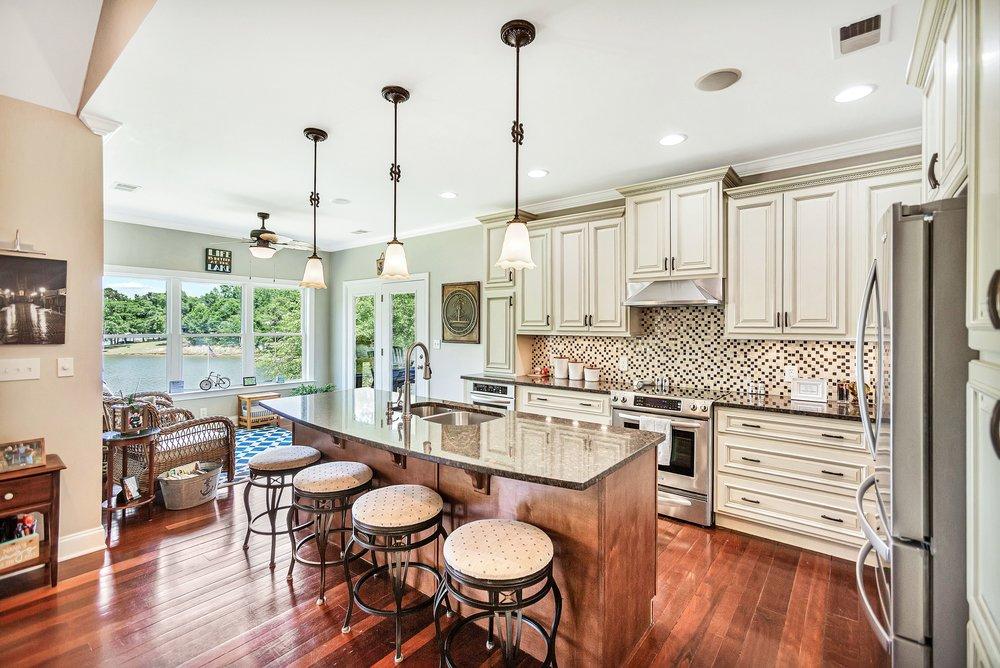 Image 4: This spacious kitchen, overlooking serene waterfro