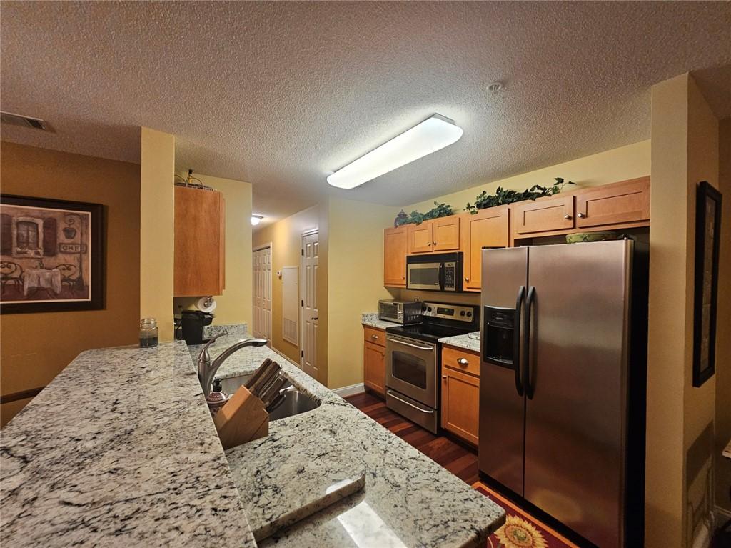 Image 4: Granite counters and stainless appliances define t