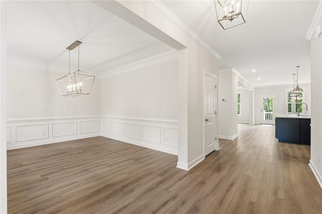 Image 4: This bright and airy room features elegant wainsco