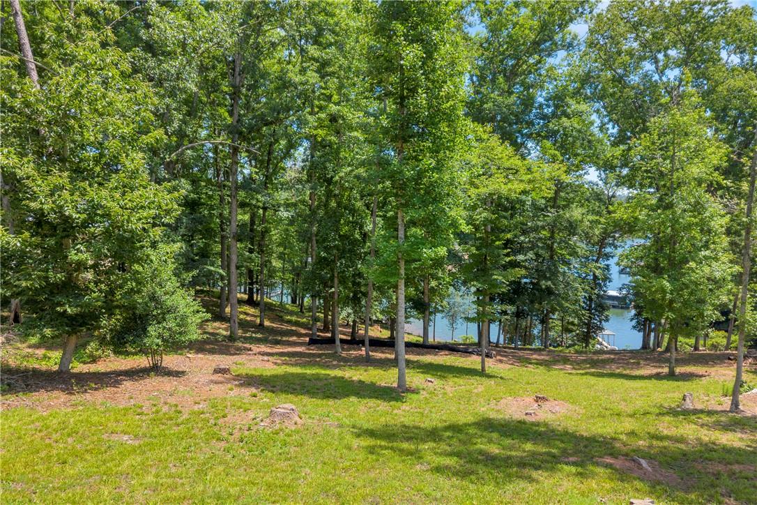 Image 4: Wooded lot with partial water views offers privacy