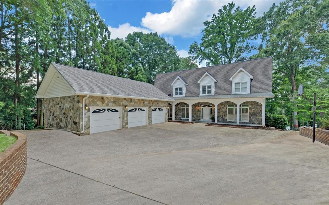 Image 1: Three-car garage and stone facade elevate this hom