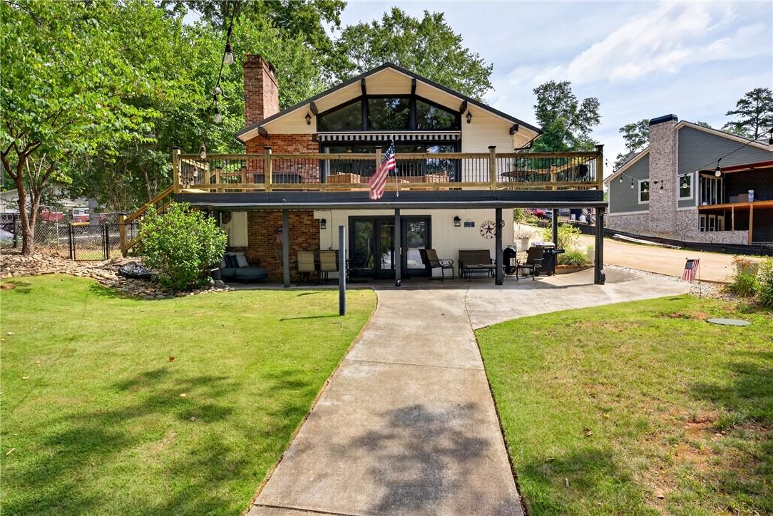 Image 2: An inviting exterior with a second-story deck offe
