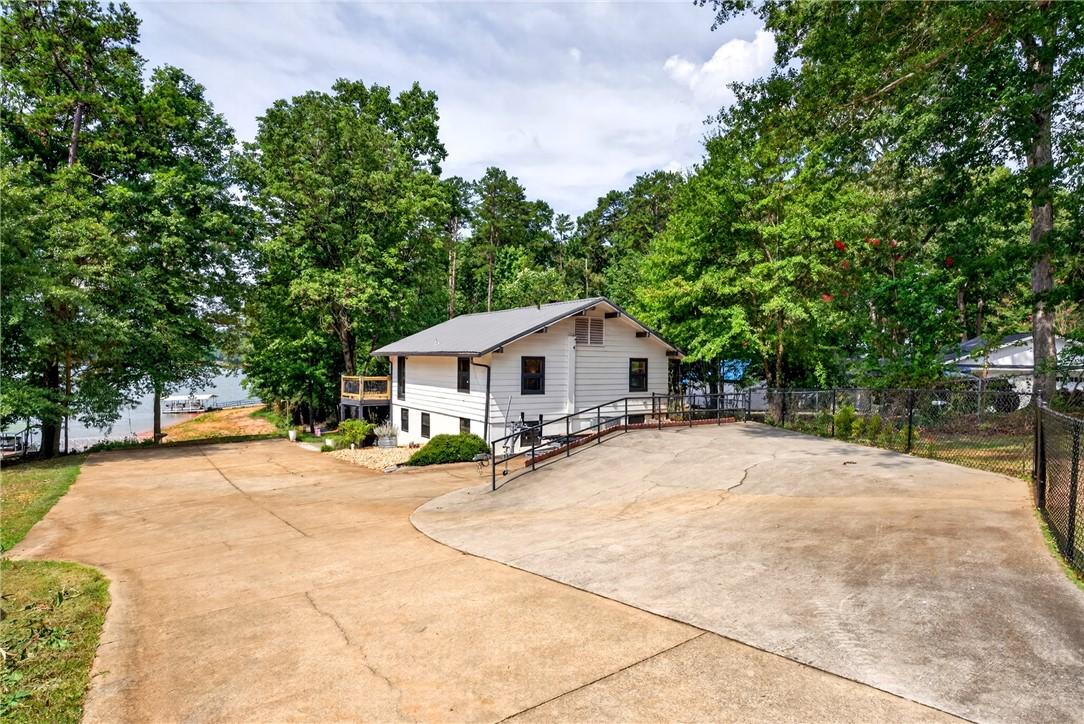 Image 4: A private driveway leads to this charming lakeside