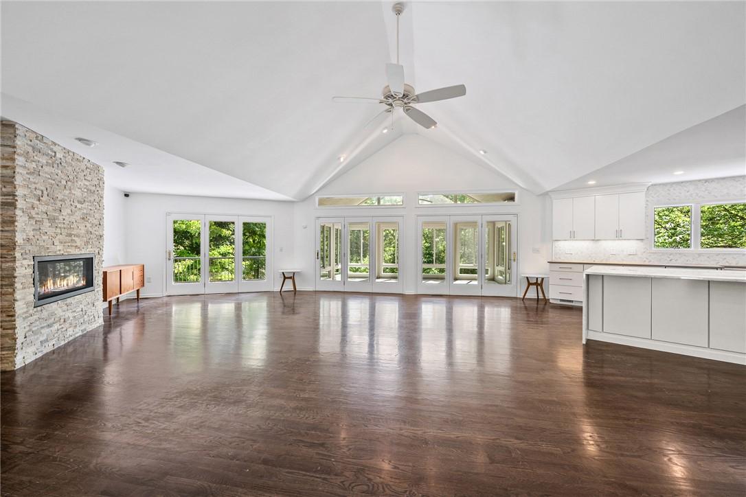 Image 3: A spacious, airy great room features hardwood floo