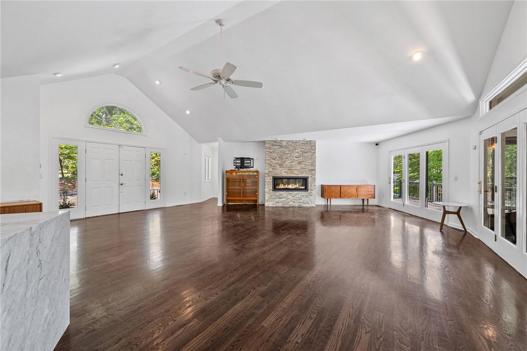 Image 4: A spacious living area features rich hardwood floo