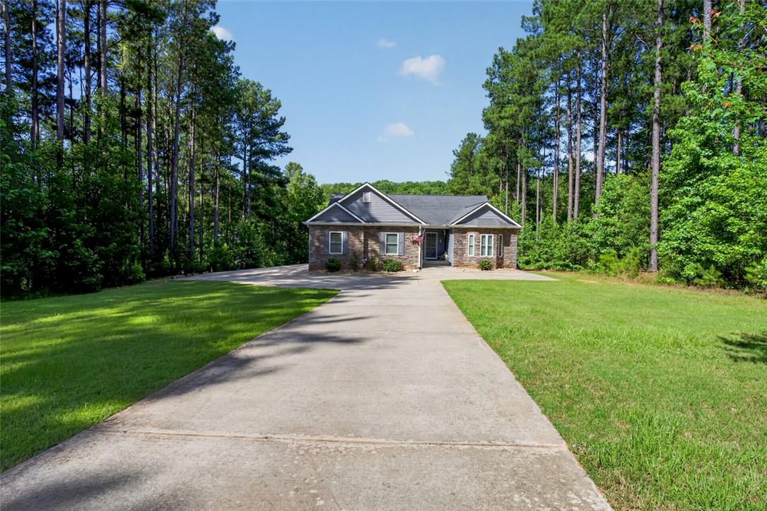 Image 1: A long paved driveway leads to a welcoming home ne