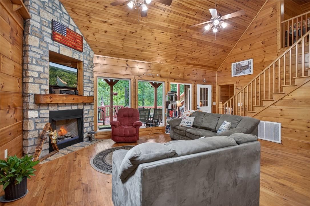 Image 3: A spacious living area with hardwood floors, a sto
